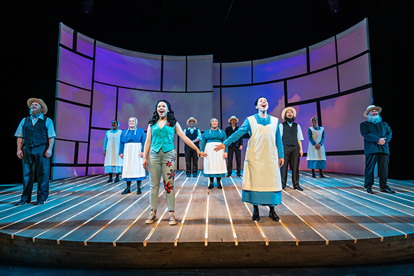 The cast of Grow performs on stage.