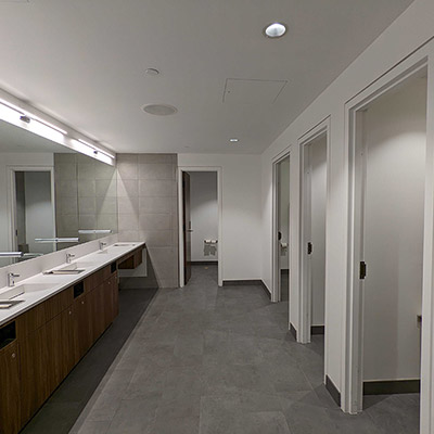 A view inside an all-gender washroom, showing the private stalls with floor-to-ceiling doors and walls.