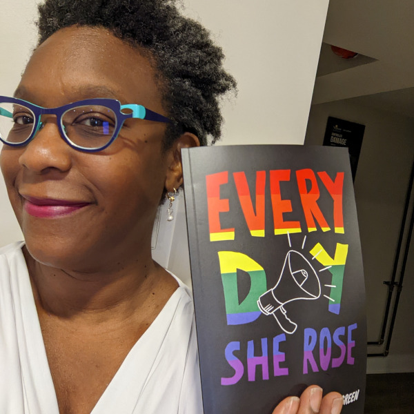 Photo of playwright Andrea Scott holding a copy of her play, Every Day She Rose