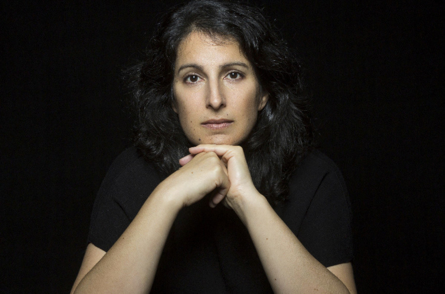 Photo of Zorana Sadiq, wearing black in front of a black background.