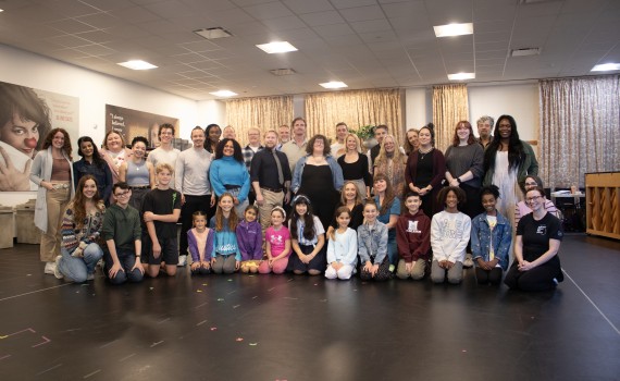 The cast and creative team of the Grand Theatre's 2024 production of The Sound of Music pose together for a group photo in the rehearsal hall.