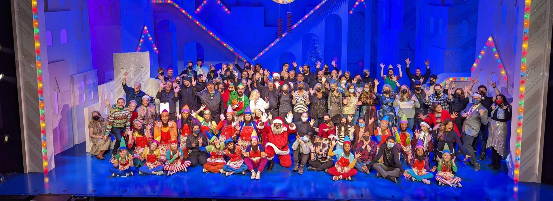 The cast (in costume), creative team and crew of Elf, along with Grand Theatre staff pose on the set of Elf on the Spriet Stage.