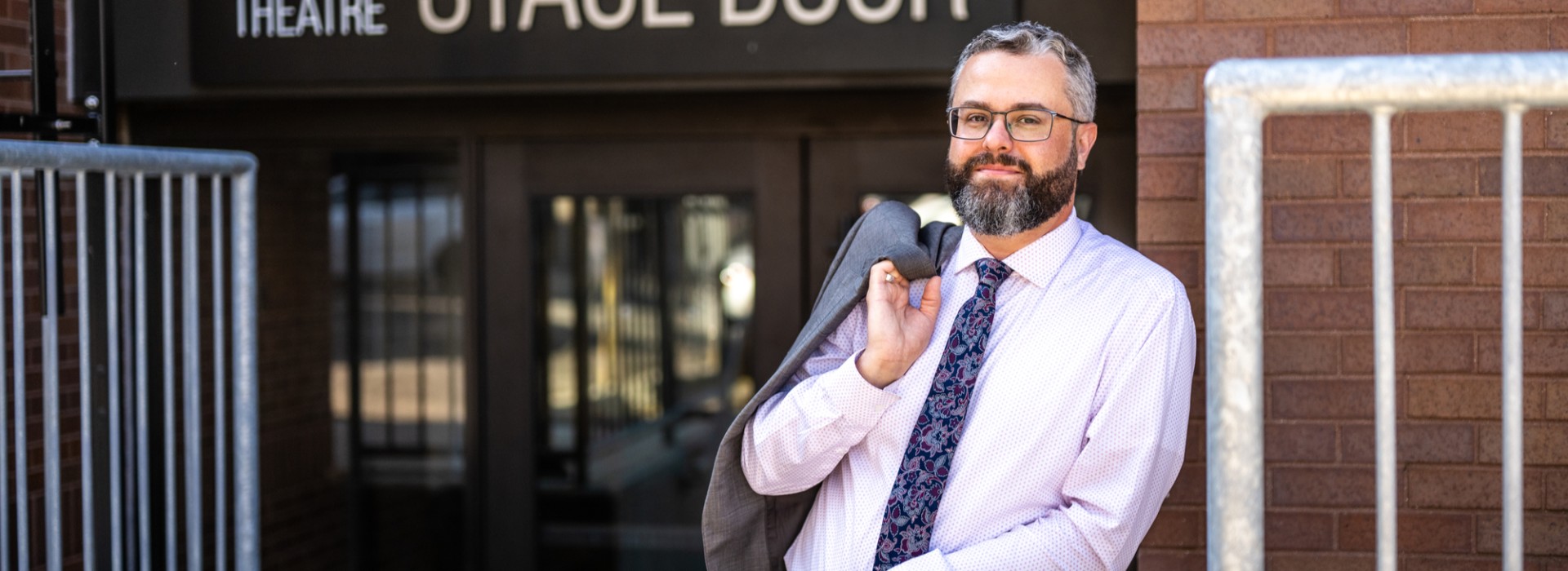 Evan Klassen stands at the stage door of the Grand Theatre