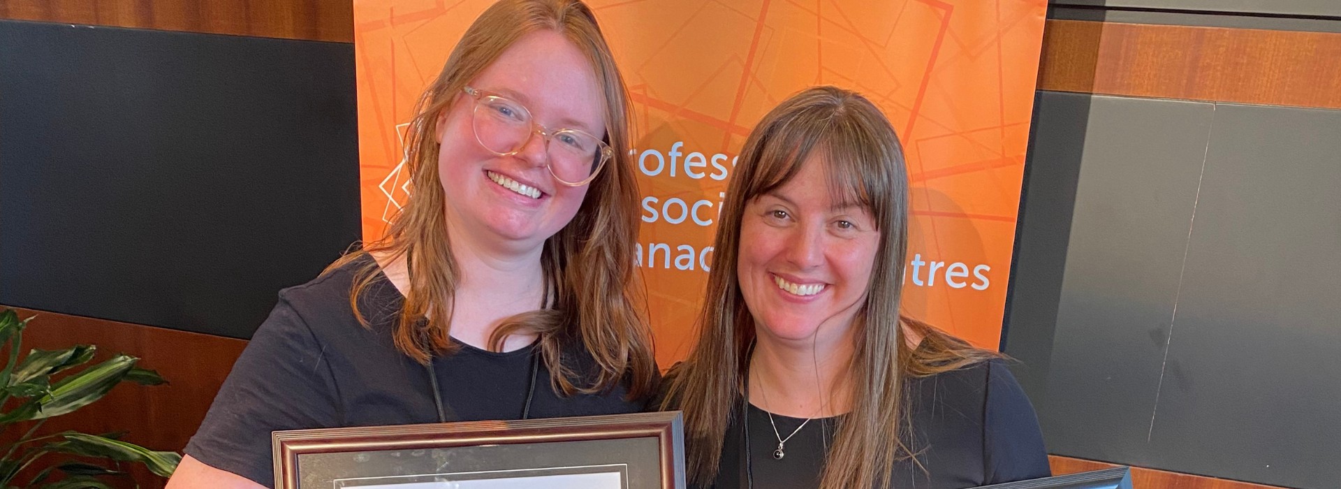 Christine Gruenbauer and Lyndee Hansen post for a photo with awards at PACT Con.