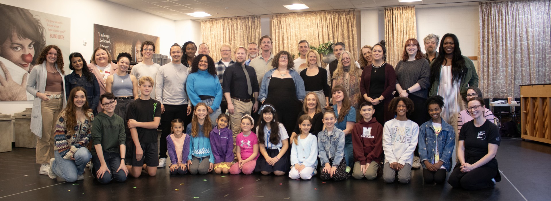 The cast and creative team of the Grand Theatre's 2024 production of The Sound of Music pose together for a group photo in the rehearsal hall.