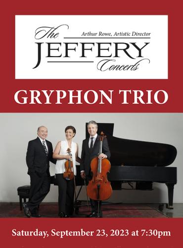 The three members of the Gryphon Trio stand in front of a piano as they pose with their instruments.